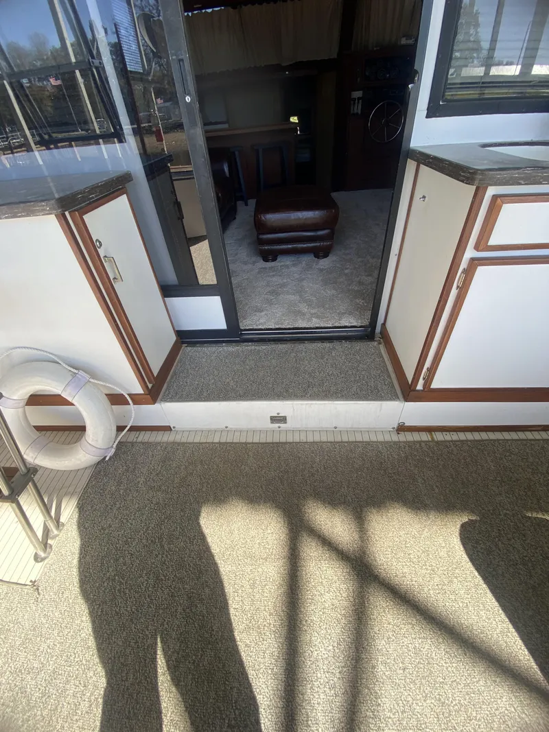 Slide: The Image of Interior view of 1989 Marinette 41 Marquis Convertible yacht, featuring carpeted flooring and cabinetry. - 27