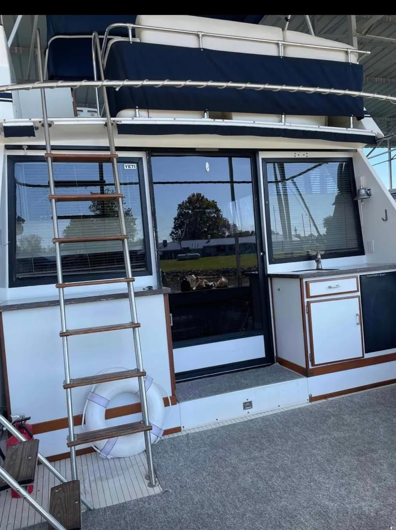 Slide: The Image of 1989 Marinette 41 Marquis Convertible yacht with ladder and outdoor seating area. - 30