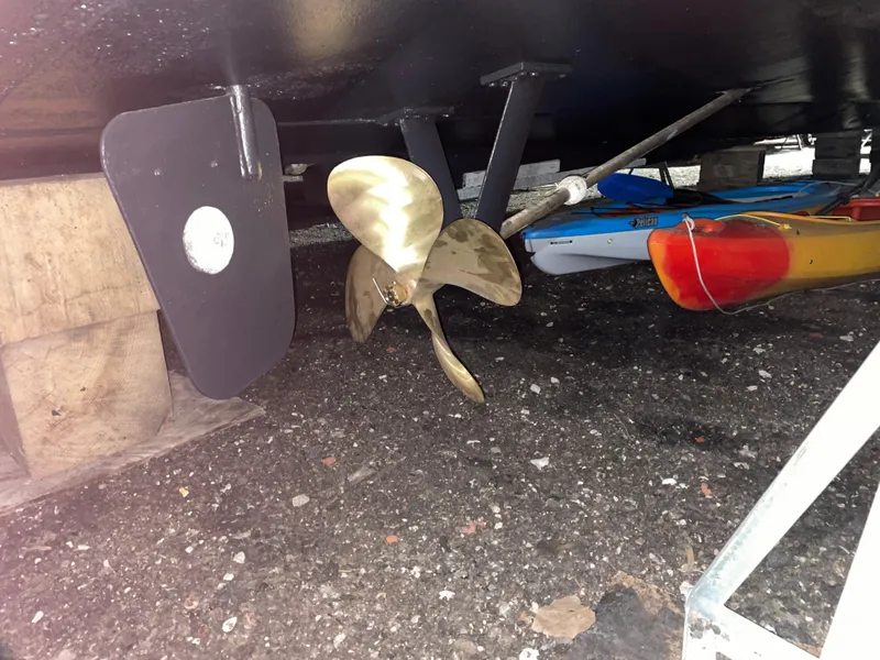 Slide: The Image of 1989 Marinette 41 Marquis Convertible propeller and rudder, with kayaks in the background. - 7