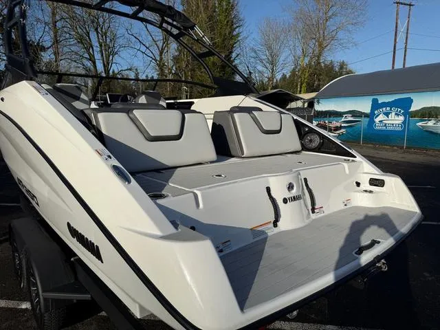 Slide: The Image of 2025 Yamaha Boats AR250, white exterior, parked outdoors near a boat dealership. - 4