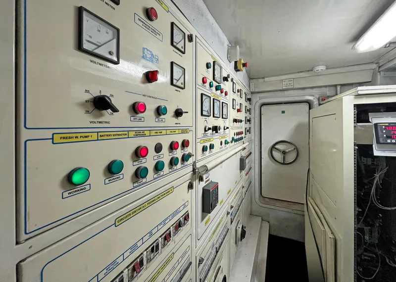 Slide: The Image of Control room of a 2003 Benetti 115 Classic yacht, featuring various switches and gauges. - 22