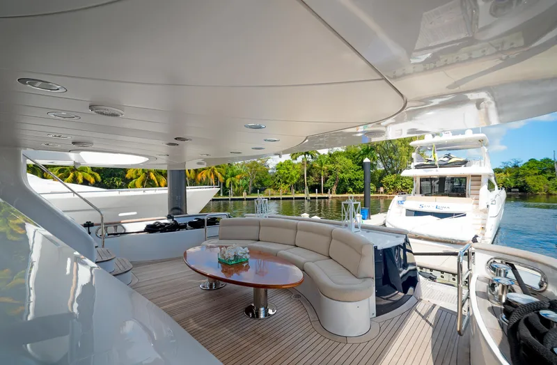 Slide: The Image of Luxurious 2003 Benetti 115 Classic yacht with elegant outdoor seating and scenic marina view. - 3