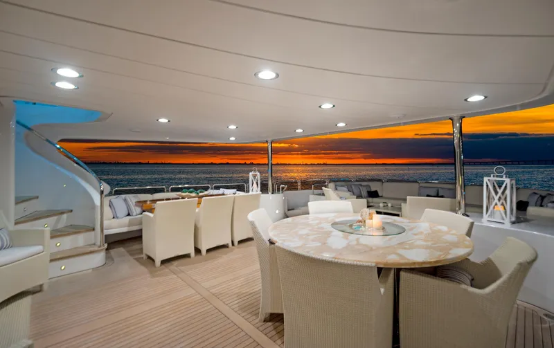 Slide: The Image of Luxurious Benetti 115 Classic yacht deck with elegant seating, sunset view, and ambient lighting. - 6