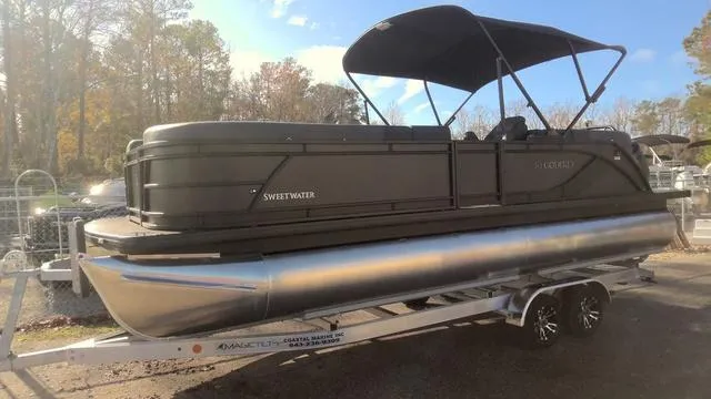Slide: The Image of 2025 Godfrey Sweetwater 2286 SB GTP pontoon boat, black exterior, parked outdoors. - 1