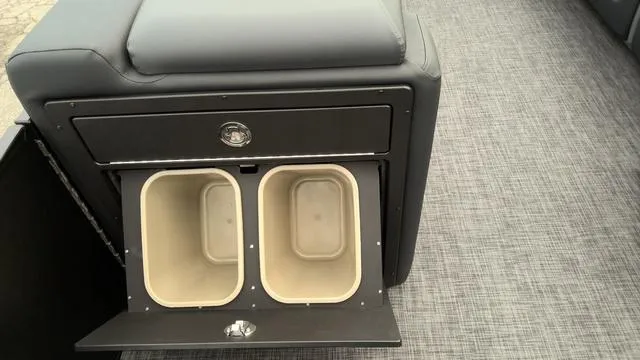 Slide: The Image of 2025 Godfrey Pontoons Sweetwater 2286 SB storage compartment with dual bins on gray flooring. - 17