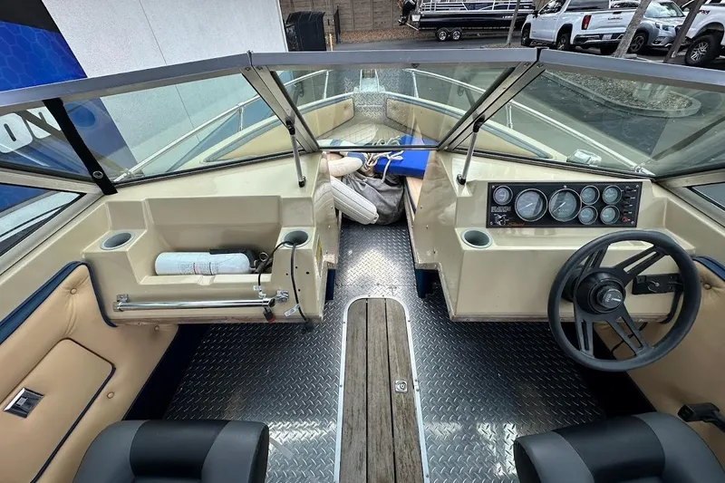 Slide: The Image of 1987 Seaswirl Sierra II boat interior with steering wheel, dashboard, and seating. - 14