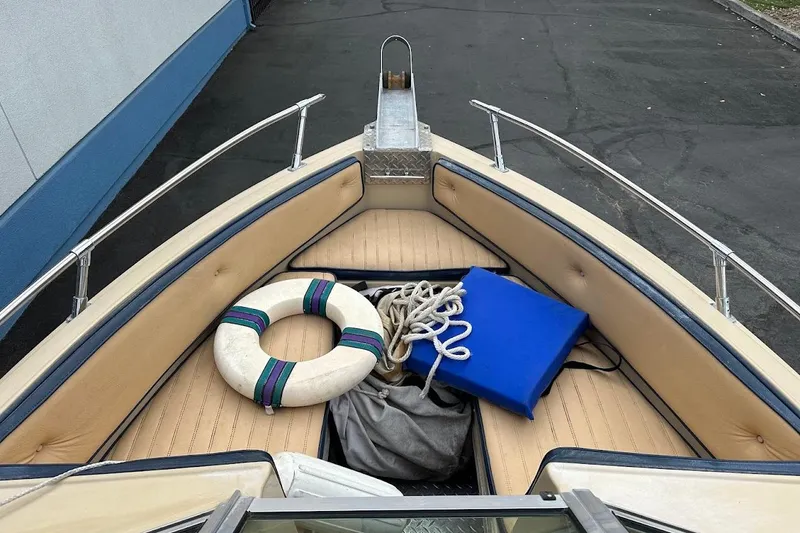 Slide: The Image of 1987 Seaswirl Sierra II boat interior with life preserver, rope, and blue cushion. - 16