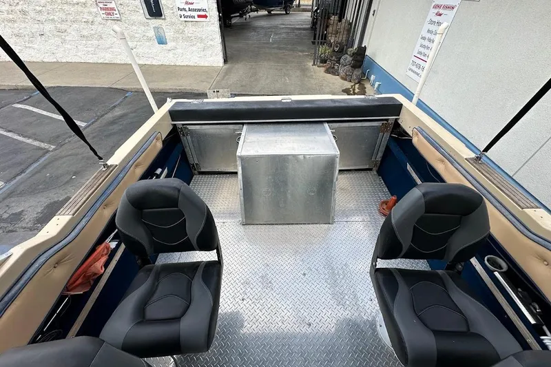 Slide: The Image of 1987 Seaswirl Sierra II boat interior with two black seats and metal flooring. - 18