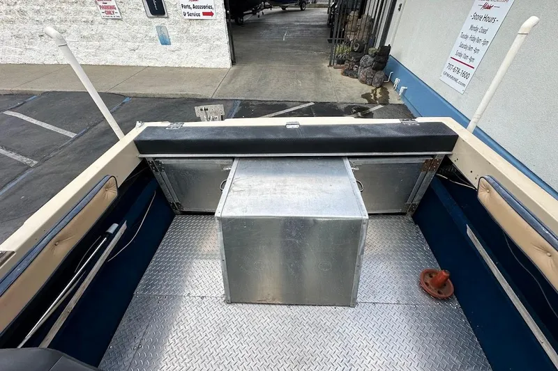 Slide: The Image of 1987 Seaswirl Sierra II boat interior with metal flooring and storage compartment. - 19