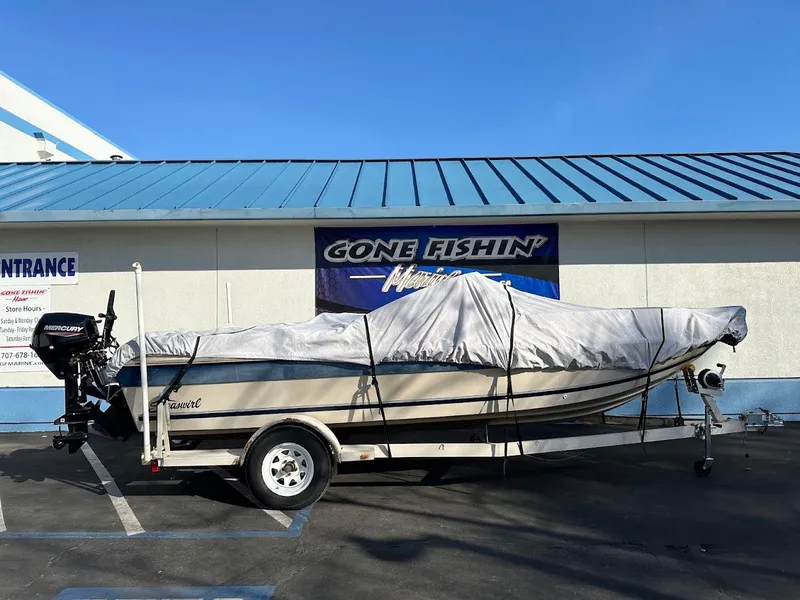 Slide: The Image of 1987 Seaswirl Sierra II boat covered on trailer, parked outside a building. - 21