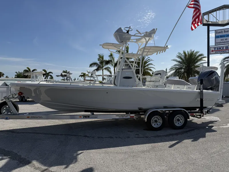 Slide: The Image of 2025 Pathfinder 2600 TRS boat on trailer, displayed outdoors with palm trees and American flag. - 2