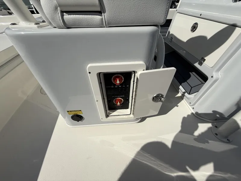Slide: The Image of 2025 Pathfinder 2600 TRS boat control panel with open compartment and switches. - 21