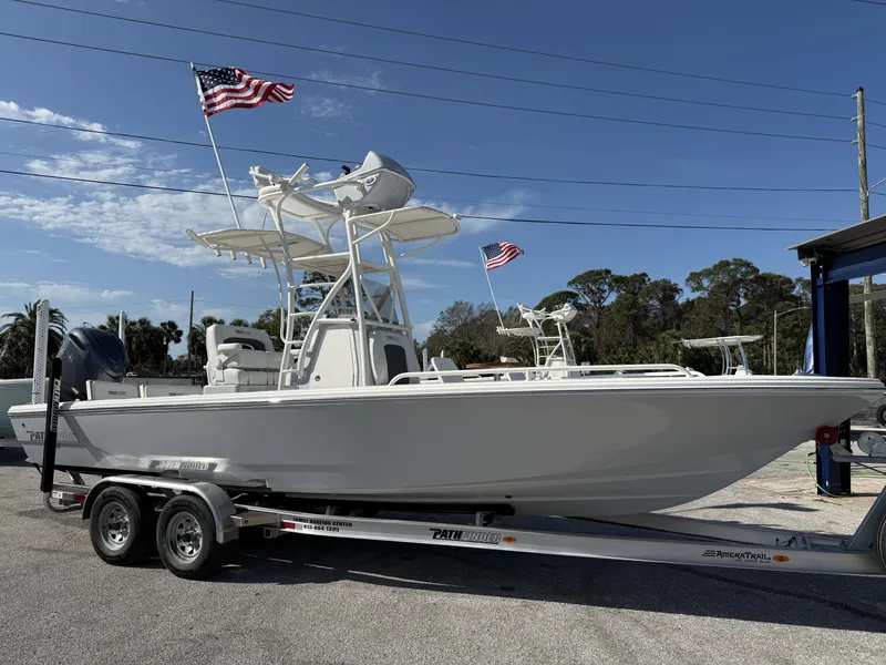 Slide: The Image of 2025 Pathfinder 2600 TRS boat on trailer with American flags, parked outdoors. - 27