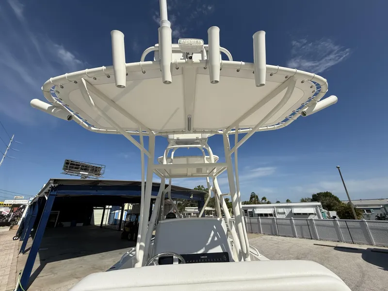 Slide: The Image of 2025 Pathfinder 2600 TRS boat with T-top and rod holders under clear blue sky. - 31