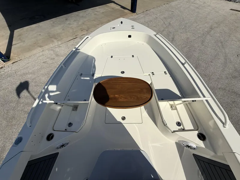 Slide: The Image of 2025 Pathfinder 2600 TRS boat deck with wooden table, storage compartments, and sleek design. - 34