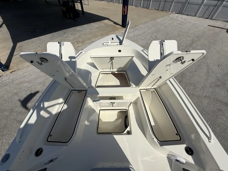 Slide: The Image of 2025 Pathfinder 2600 TRS boat with open storage compartments, docked on concrete surface. - 45