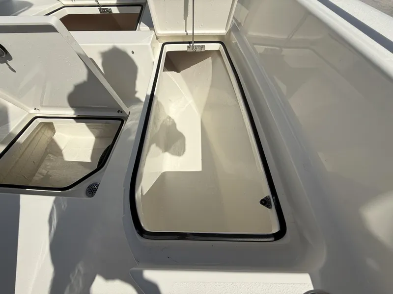 Slide: The Image of 2025 Pathfinder 2600 TRS boat storage compartments, open and empty, in bright sunlight. - 48