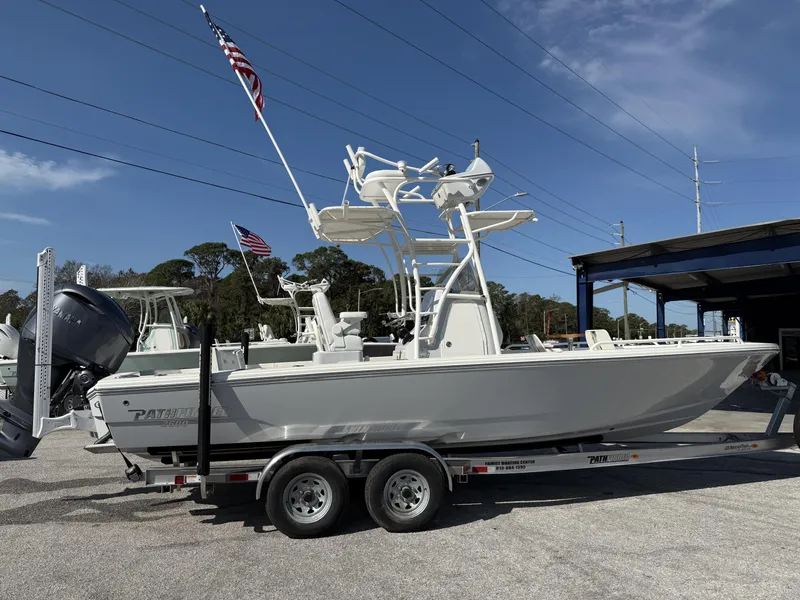 Slide: The Image of 2025 Pathfinder 2600 TRS boat on trailer, American flag, clear sky background. - 7
