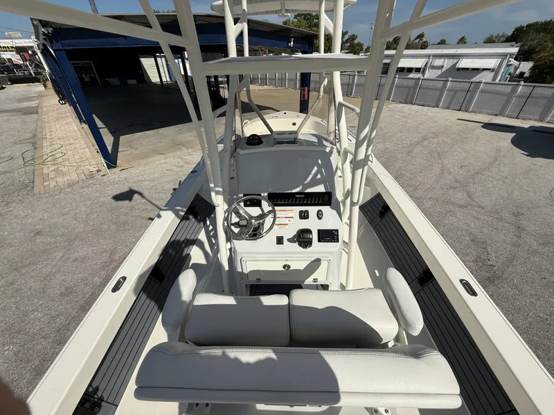 Slide: The Image of 2025 Pathfinder 2600 TRS boat interior with steering console and seating, docked outdoors. - 9