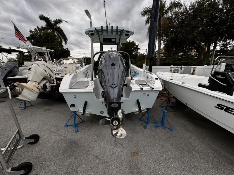 Slide: The Image of 2025 Sea Pro 245 FLX boat displayed outdoors, rear view with motor, cloudy sky. - 35