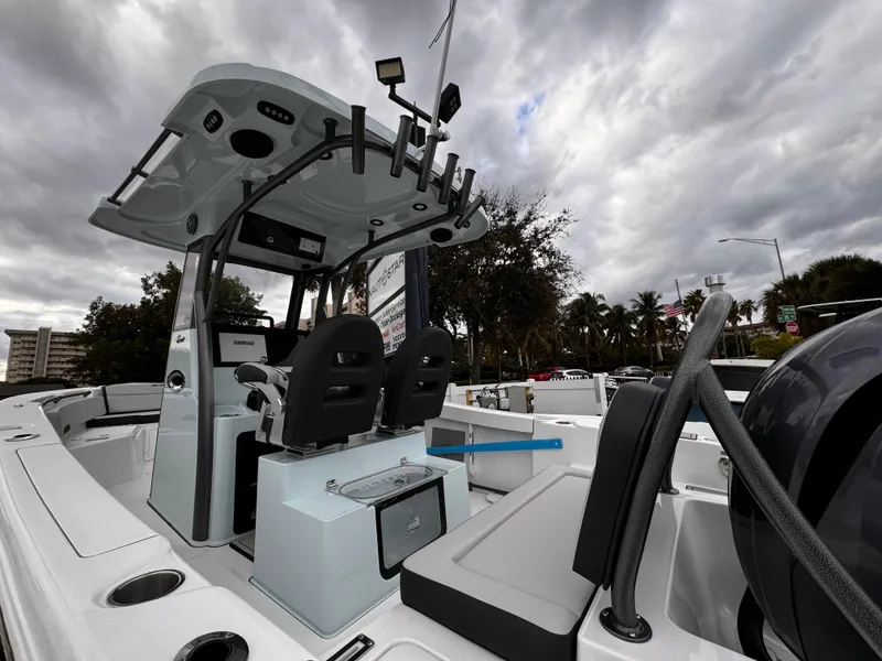 Slide: The Image of 2025 Sea Pro 245 FLX boat interior with seating and console under cloudy sky. - 37