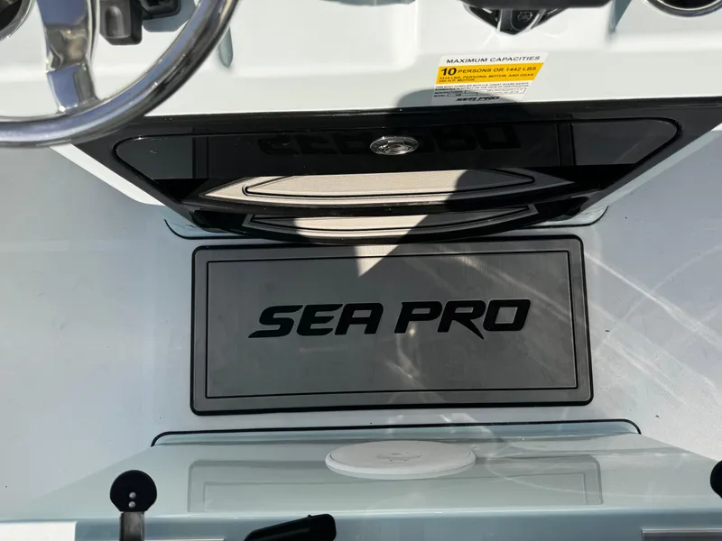 Slide: The Image of 2025 Sea Pro 245 FLX boat interior with logo and steering wheel. - 52