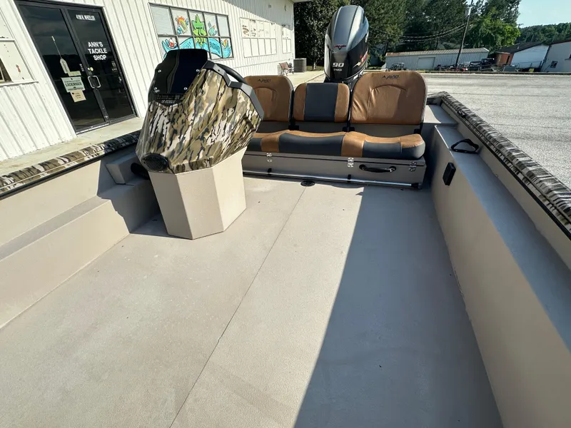 Slide: The Image of 2024 Avid 18SC Rogue boat interior with camo console and brown seating. - 10