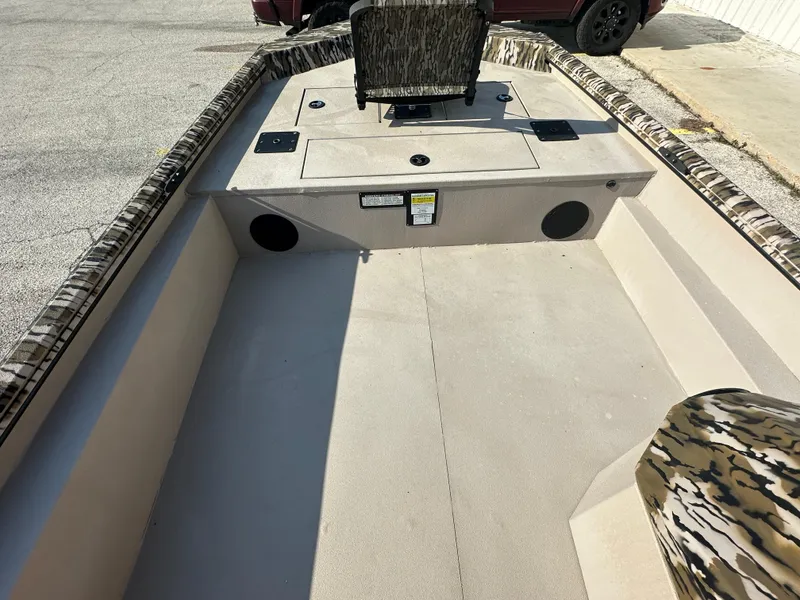 Slide: The Image of 2024 Avid 18SC Rogue boat interior with camo seating and spacious deck. - 16