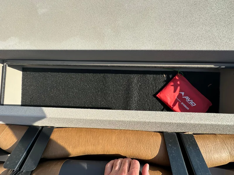 Slide: The Image of Storage compartment in 2024 Avid 18SC Rogue boat with red Avid pouch inside. - 18