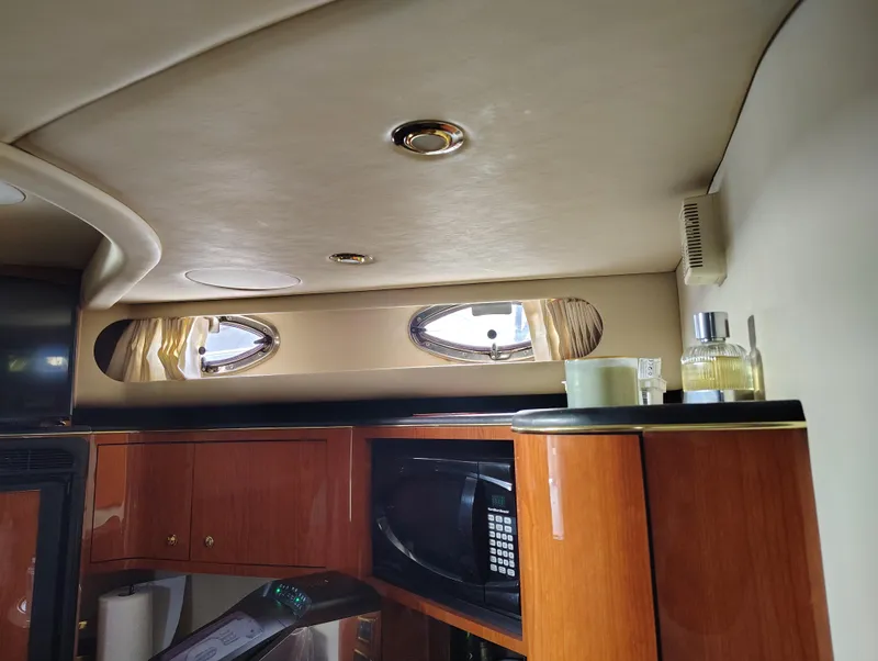 Slide: The Image of Interior of 2001 Sea Ray Sundancer yacht with wooden cabinetry and porthole windows. - 16
