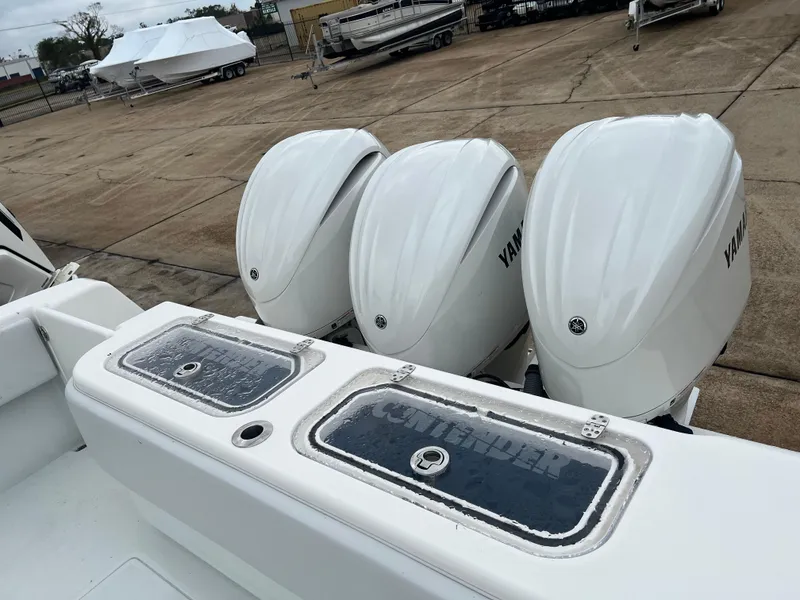 Slide: The Image of 2021 Contender 39 ST boat with triple Yamaha outboard engines in a marina. - 11