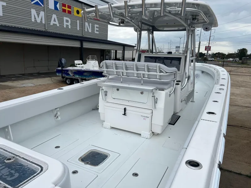 Slide: The Image of 2021 Contender 39 ST boat with spacious deck and seating at a marine facility. - 15