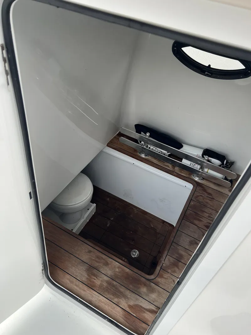 Slide: The Image of 2021 Contender 39 ST boat interior with wooden flooring and compact toilet. - 19