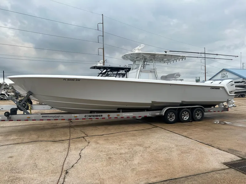 Slide: The Image of 2021 Contender 39 ST boat on trailer, parked outdoors under cloudy sky. - 3