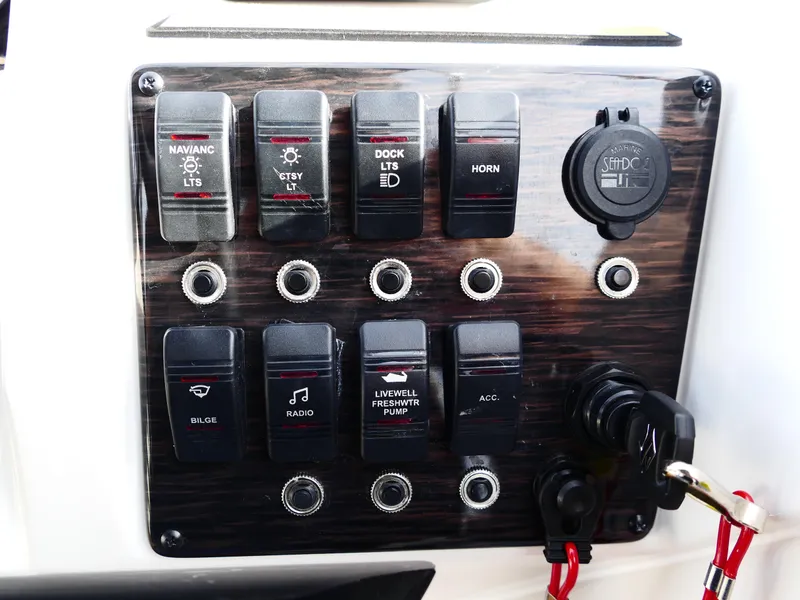 Slide: The Image of Control panel of 2025 Starcraft SVX 211 OB boat with labeled switches and key ignition. - 15