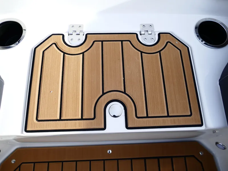 Slide: The Image of Starcraft SVX 211 OB 2025 boat deck with wood finish and cup holders. - 22