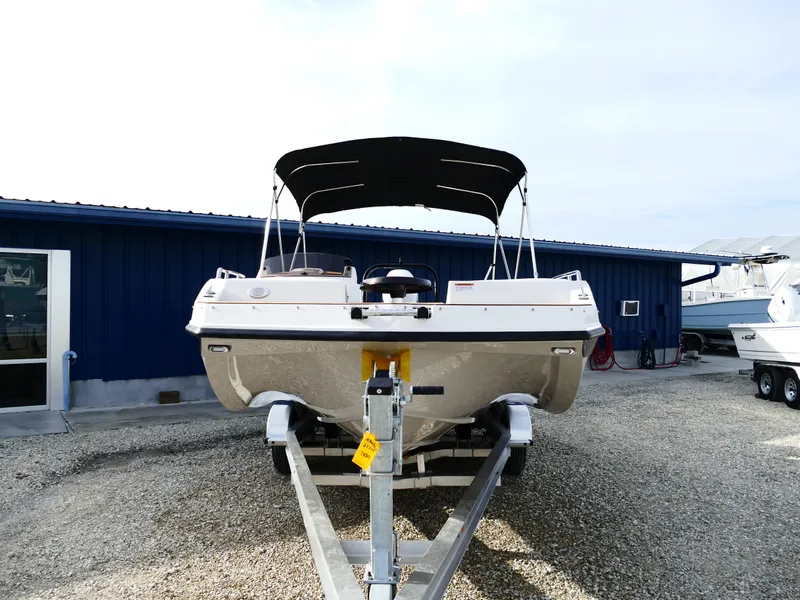 Slide: The Image of 2025 Starcraft SVX 211 OB boat on trailer, parked outside blue building. - 3