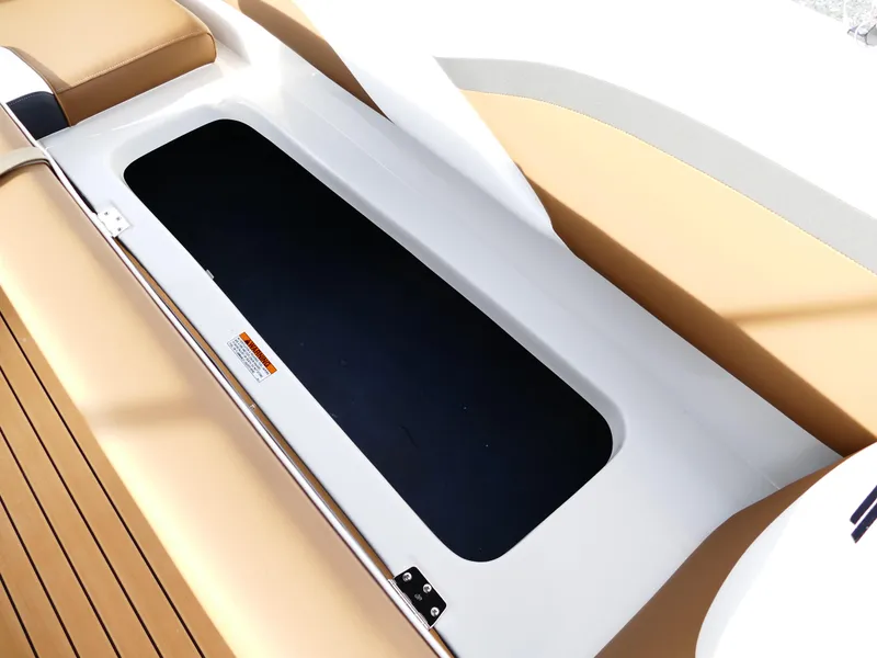 Slide: The Image of 2025 Starcraft SVX 211 OB boat storage compartment with tan seating and sleek design. - 31