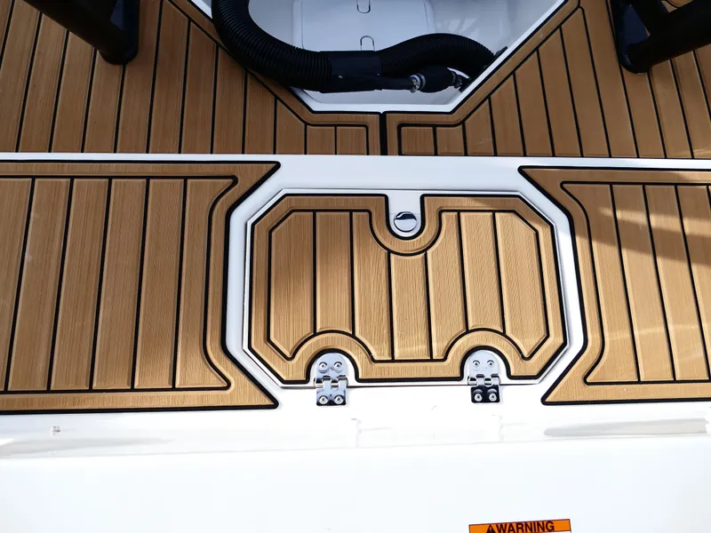 Slide: The Image of Starcraft SVX 211 OB 2025 boat deck with wood finish and storage hatch. - 36