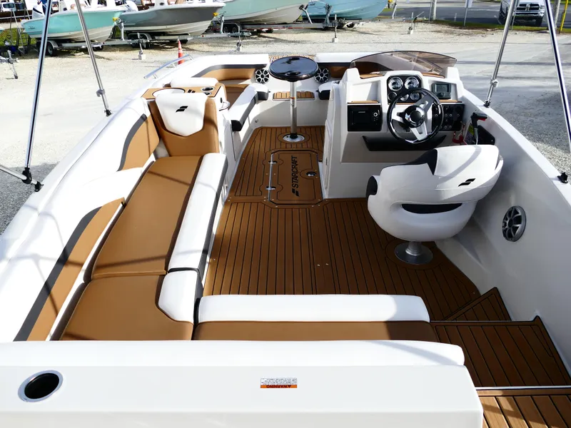 Slide: The Image of 2025 Starcraft SVX 211 OB boat interior with tan seating and modern dashboard. - 8