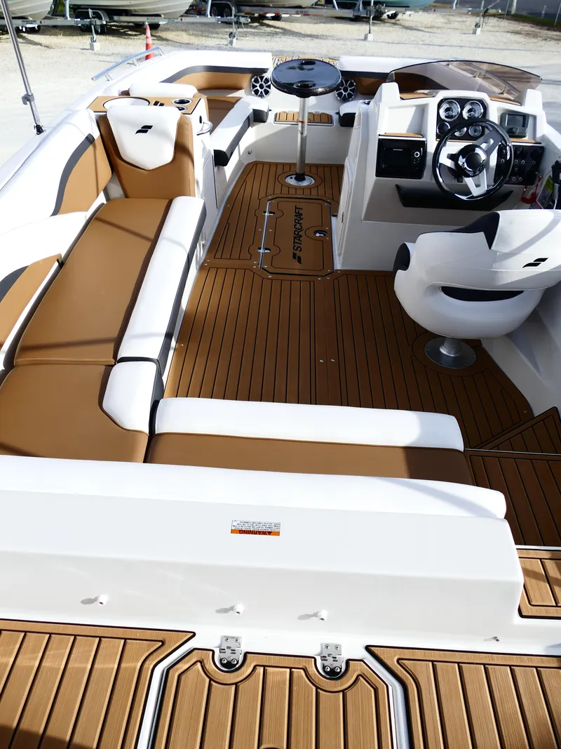 Slide: The Image of 2025 Starcraft SVX 211 OB boat interior with tan seating and modern dashboard. - 9