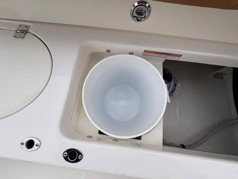 Slide: The Image of 2025 Robalo 202 EXPLORER boat interior with storage compartment and bucket. - 13