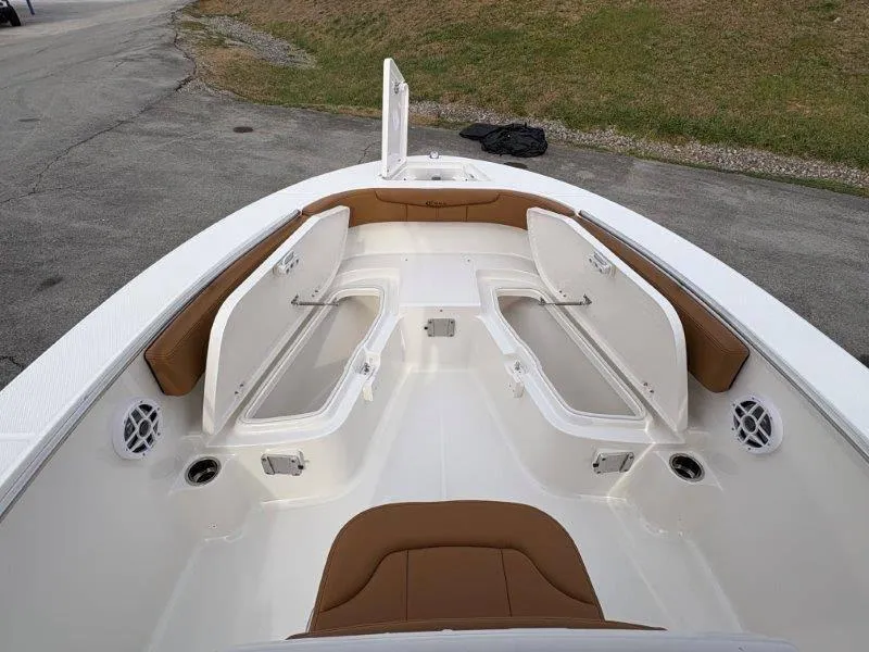 Slide: The Image of 2025 Robalo 202 EXPLORER boat interior with open storage compartments and brown seating. - 26