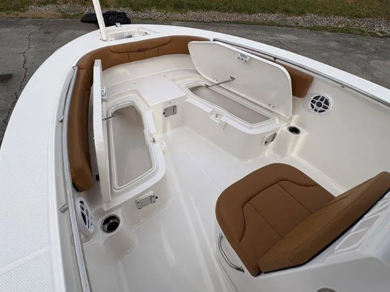 Slide: The Image of 2025 Robalo 202 EXPLORER boat interior with brown seating and open storage compartments. - 28