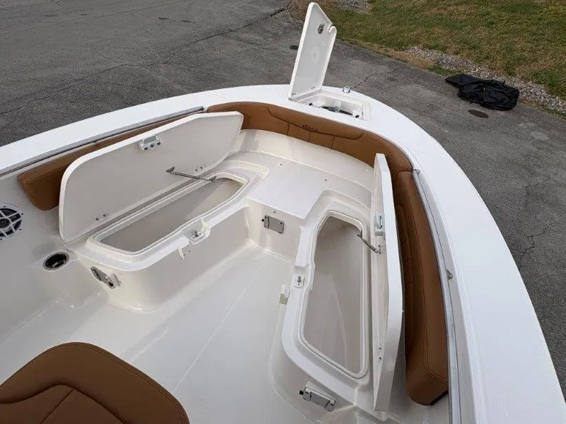Slide: The Image of 2025 Robalo 202 EXPLORER boat interior with open storage compartments and cushioned seating. - 29
