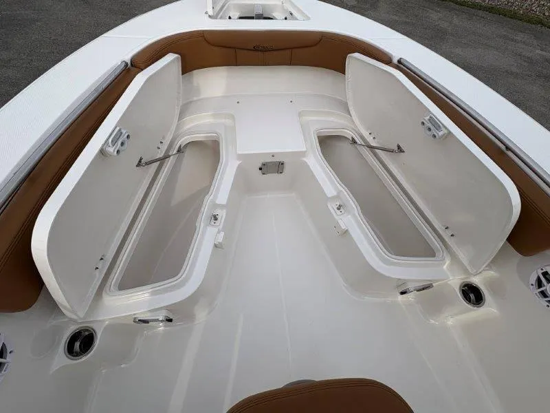 Slide: The Image of 2025 Robalo 202 EXPLORER boat with open storage compartments and brown seating. - 32