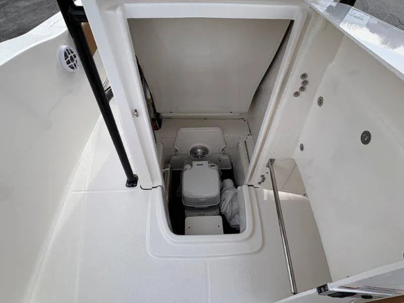 Slide: The Image of 2025 Robalo 202 EXPLORER boat interior with compact marine toilet. - 34