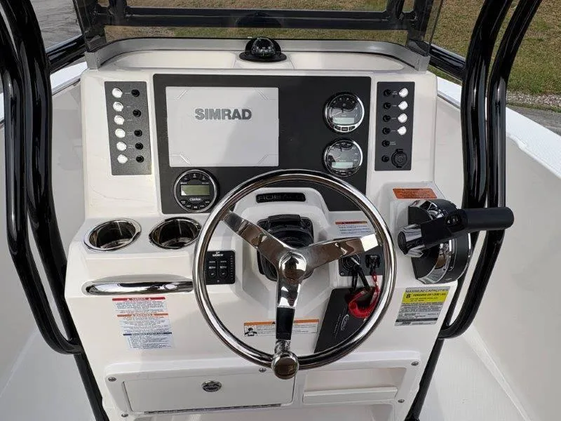 Slide: The Image of 2025 Robalo 202 EXPLORER boat dashboard with Simrad display and steering wheel. - 39