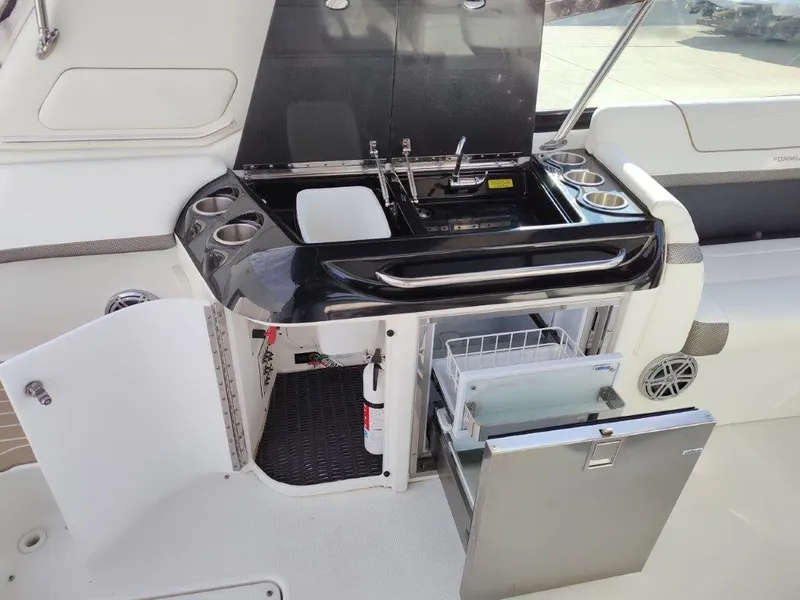 Slide: The Image of 2018 Formula 350 Crossover Bowrider kitchenette with sink, storage, and mini fridge. - 18