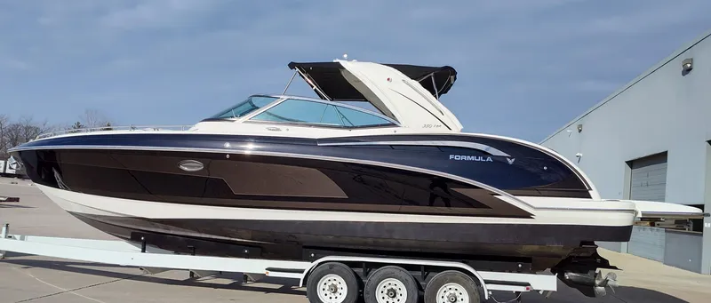 Slide: The Image of 2018 Formula 350 Crossover Bowrider on trailer, sleek design, parked outdoors. - 2